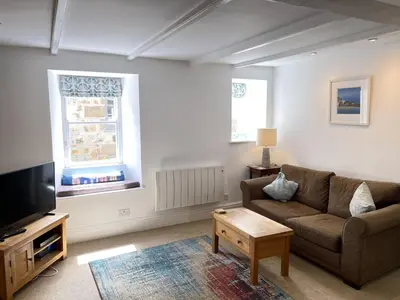 a living room with a couch and a tv at Howards Way in St Ives