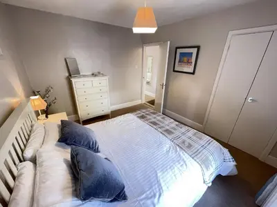 a bedroom with a large bed with blue pillows at Howards Way in St Ives