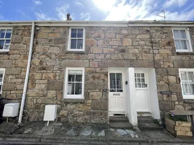 an old stone house with white doors and windows at Howards Way in St Ives