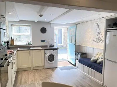 a kitchen with a washing machine and a sink at Howards Way in St Ives
