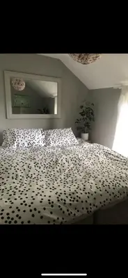 a bedroom with a bed with a black and white blanket at Greenbank Farm in Falmouth