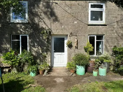 a house with potted plants in front of a door at Greenbank Farm in Falmouth