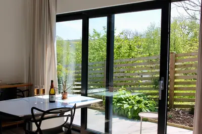 a dining room with a table and a glass door at Cicero's Lodge in Padstow