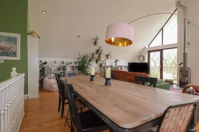 a dining room with a wooden table and chairs at 6 The Links in Penzance