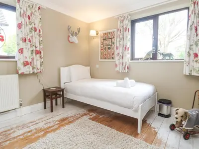 a bedroom with a white bed and a window at 6 The Links in Penzance