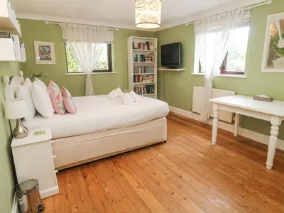 a bedroom with a bed and a desk in it at 6 The Links in Penzance