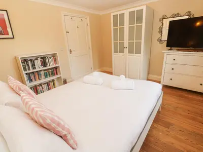 a bedroom with a white bed and a tv at 6 The Links in Penzance
