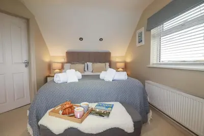 a bedroom with a bed with a book and a tray of food at Coastman's Nest in Newquay