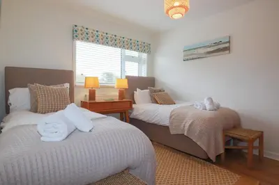 a bedroom with two beds and a window at Coastman's Nest in Newquay