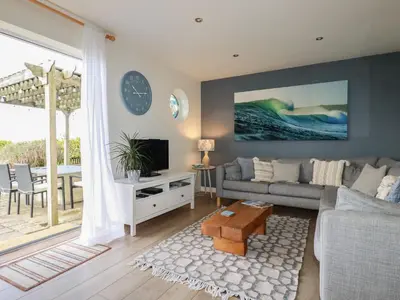 a living room with a couch and a table at Coastman's Nest in Newquay