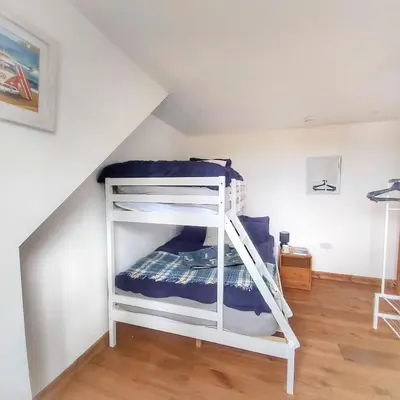 a white bunk bed in a room with a ladder at Heart of Kernow Holiday Home in Bugle