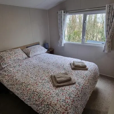 a bedroom with a bed with two towels on it at 7 Bays 6 Berth Willerby Molton Caravan in St Merryn
