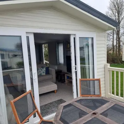 a screened in porch with a chair and a couch at 7 Bays 6 Berth Willerby Molton Caravan in St Merryn