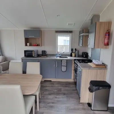 a small kitchen with a sink and a table at 7 Bays 6 Berth Willerby Molton Caravan in St Merryn