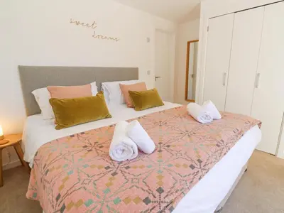 a bedroom with a large bed with towels on it at Azure Retreat at Una in St Ives