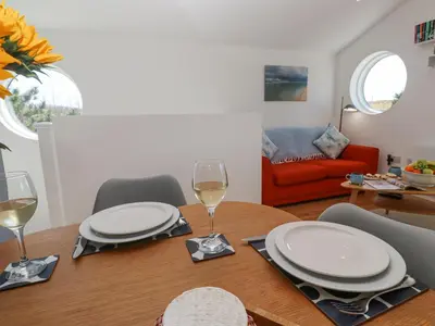 a dining room table with white plates and wine glasses at Azure Retreat at Una in St Ives