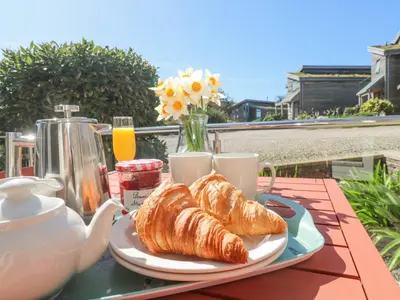a table with a plate of croissants and a teapot at Azure Retreat at Una in St Ives