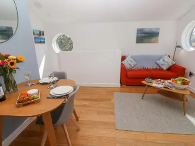 a living room with a table and a couch at Azure Retreat at Una in St Ives
