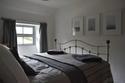 a bedroom with a bed with two pillows on it at North Cornwall character cottage, sleeps 5, close to coast in Delabole