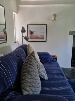 a blue bed with pillows in a bedroom at North Cornwall character cottage, sleeps 5, close to coast in Delabole