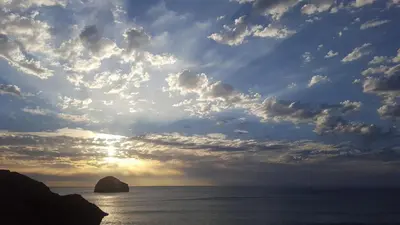 a cloudy sky with the sun in the ocean at North Cornwall character cottage, sleeps 5, close to coast in Delabole