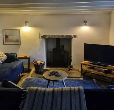 a living room with a couch and a tv at North Cornwall character cottage, sleeps 5, close to coast in Delabole
