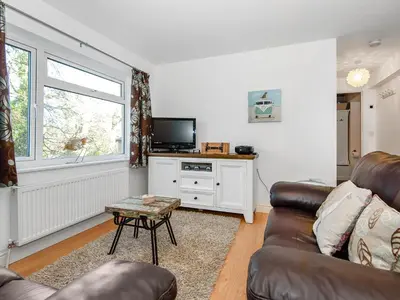 a living room with a couch and a tv at Low Tide in Looe