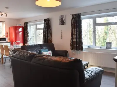 a living room with a leather couch and a table at Low Tide in Looe