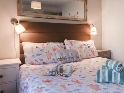 a bedroom with a bed with a tray of food on it at Low Tide in Looe