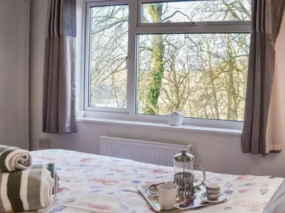 a bedroom with a bed and a window at Low Tide in Looe