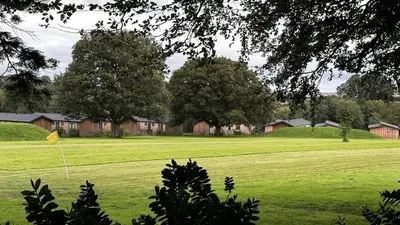 a green field with a yellow kite in the grass at Manor Lake Lodge Exclusive luxury lodge retreat in Saint Tudy