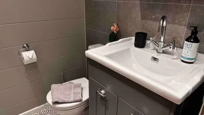 a bathroom with a sink and a toilet at Manor Lake Lodge Exclusive luxury lodge retreat in Saint Tudy