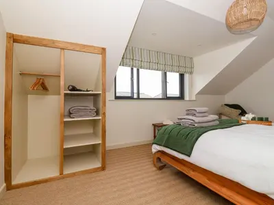 a bedroom with a bed and a mirror at The Cabin at Ropewalk in St. Agnes
