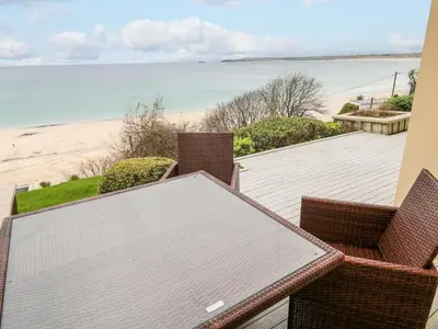 a table and chairs with a view of the beach at Sandwaves in St Ives