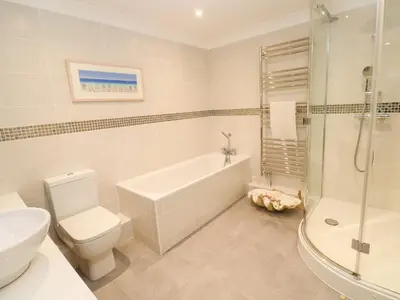 a bathroom with a toilet and a tub and a sink at Sandwaves in St Ives