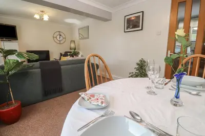 a dining room with a table and a couch at Ty Metheven in Camborne