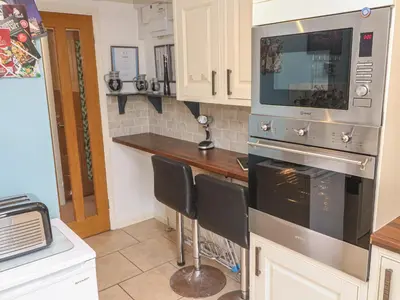 a kitchen with a stove and a microwave at Ty Metheven in Camborne