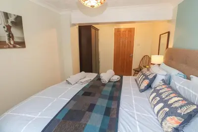 a bedroom with a large bed and a couch at Ty Metheven in Camborne