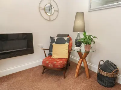 a living room with a chair and a table at Ty Metheven in Camborne
