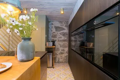 a vase with flowers on a table in a kitchen at She Sells Sanctuary in St Ives