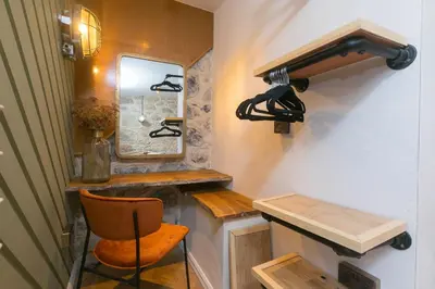 a small room with a mirror and a chair at She Sells Sanctuary in St Ives