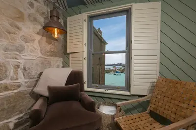 a room with a window and a couch and a chair at She Sells Sanctuary in St Ives