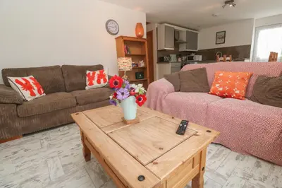 a living room with two couches and a coffee table at Sea View Loft in Penzance