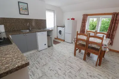 a kitchen with a table and chairs and a kitchen with a sink at Sea View Loft in Penzance