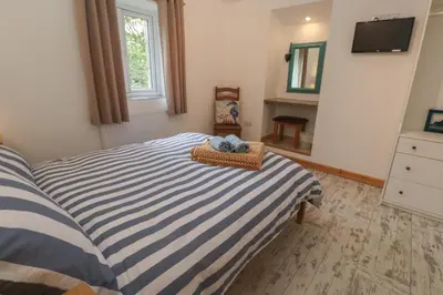 a bedroom with a blue and white striped bed at Sea View Loft in Penzance