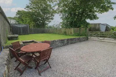 a patio with a table and chairs and a garden at Sea View Loft in Penzance