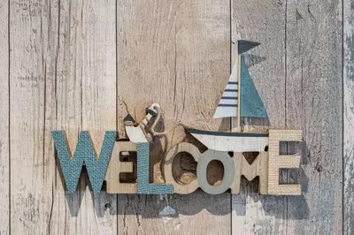 a wooden sign with a sailboat and the word warlords at Beautiful Quayside Cottage Looe in Looe