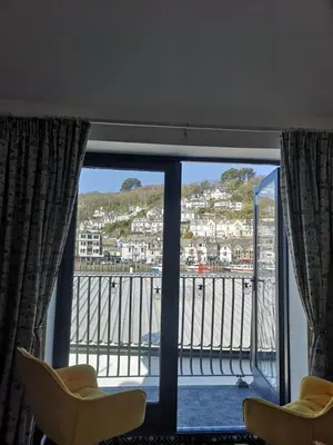 a room with a window with a view of a harbor at Beautiful Quayside Cottage Looe in Looe