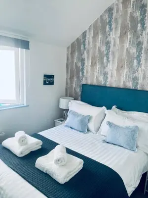a bedroom with two towels on a bed at Beautiful Quayside Cottage Looe in Looe