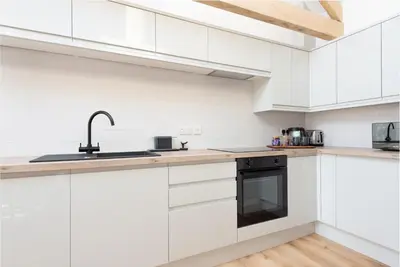 a kitchen with white cabinets and a sink at Hednes Barn in Crowan